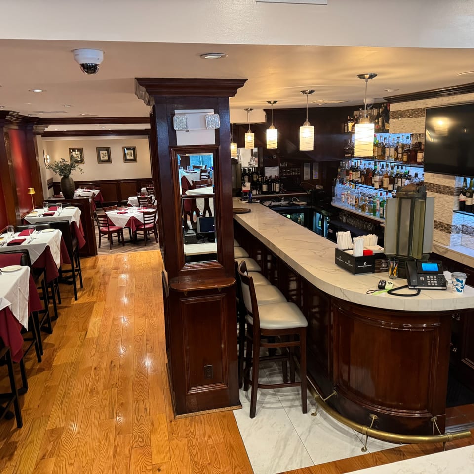Pietro's Italian restaurant interior with a fully stocked bar and dining area with set tables.