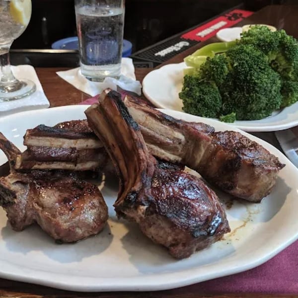 Grilled lamb chops with a side of steamed broccoli and drinks at Pietro's, an Italian restaurant.