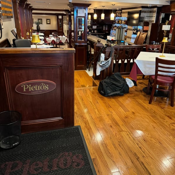 Pietro's Italian restaurant interior with dark wood, white tablecloths, and a bar area.