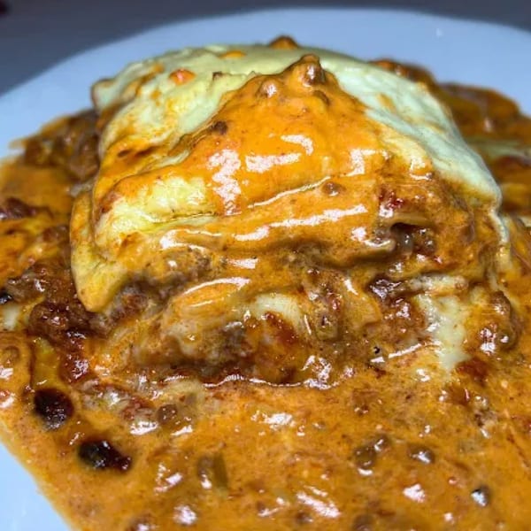 Pietros' Italian lasagna, a hearty dish with rich meat sauce and melted cheese, served on a white plate.