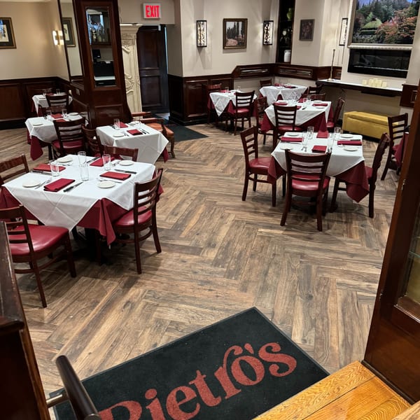 Pietro's Italian restaurant dining room with tables set with white tablecloths and red napkins.